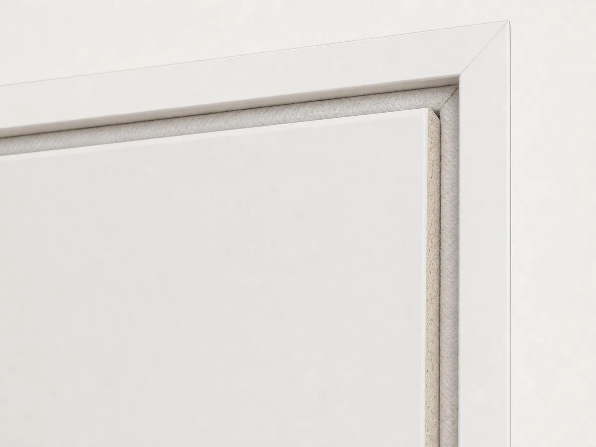 A closed fire-rated loft hatch panel seated against its frame, with the intumescent seal visible around the edge